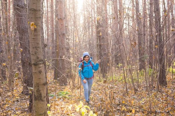 Avontuur, reizen, toerisme, wandeling en mensen concept - aantrekkelijke lachende toeristische vrouw lopen in de dikke van het bos — Stockfoto