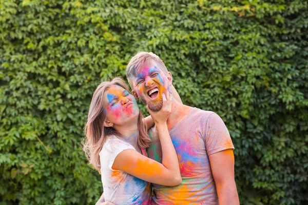 Conceito de férias, holi e pessoas - Casal feliz se divertindo coberto de tinta — Fotografia de Stock