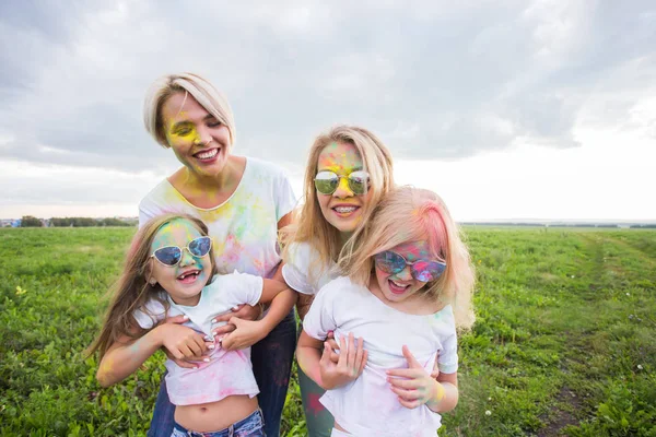 Holi festival, helgdagar och lycka koncept - unga tonåringar och kvinnor i färger har kul utomhus — Stockfoto