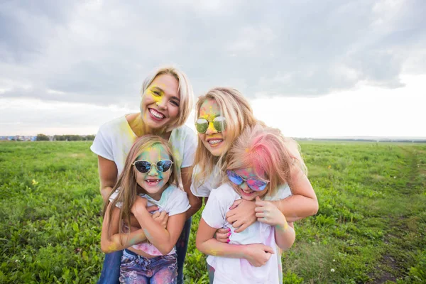 Familie, festival van holi en feestdagen concept - portret van moeders en dochters bedekt met verf — Stockfoto