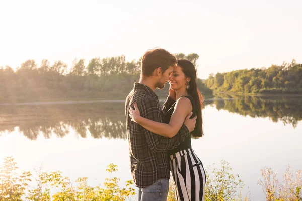 Aşk, romantik ve doğa kavramı - göl kenarında sarılma genç çift