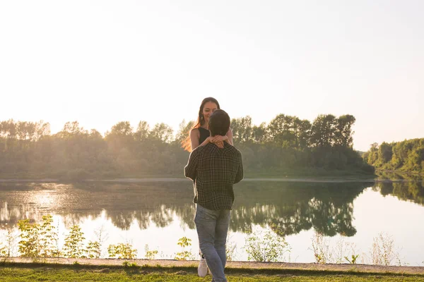 La gente, el amor y el concepto de la naturaleza - Mujer hermosa joven y hombre guapo abrazándose unos a otros sobre el fondo de agua —  Fotos de Stock