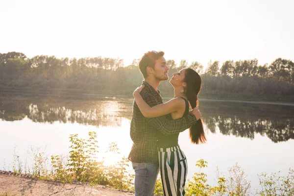 Pessoas, amor e conceito de natureza - Retrato de jovem casal bonito abraçando uns aos outros, enquanto em pé sobre o fundo da natureza — Fotografia de Stock