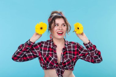 mavi arka plan üzerinde iki gerberas ile pin-up kadın