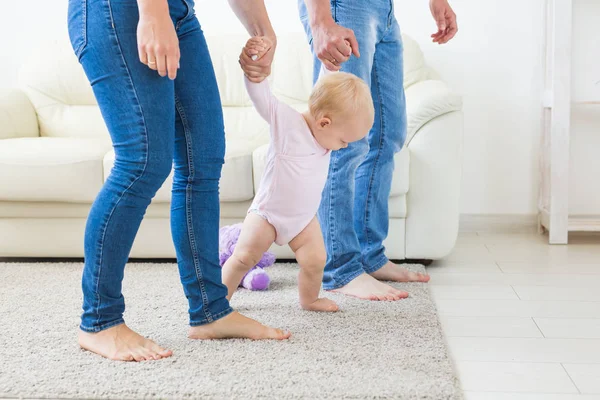 Family, children and parenthood concept - Parents teaching baby girl to walk — Stock Photo, Image