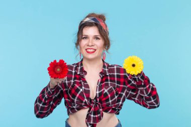 Yaz, pin-up ve eğlenceli kavram - mavi arka plan üzerinde gerberas ile güzel kadın