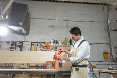 Mobilya fabrikasında çalışan genç sakallı adam, mobilya için renk eşleştirme