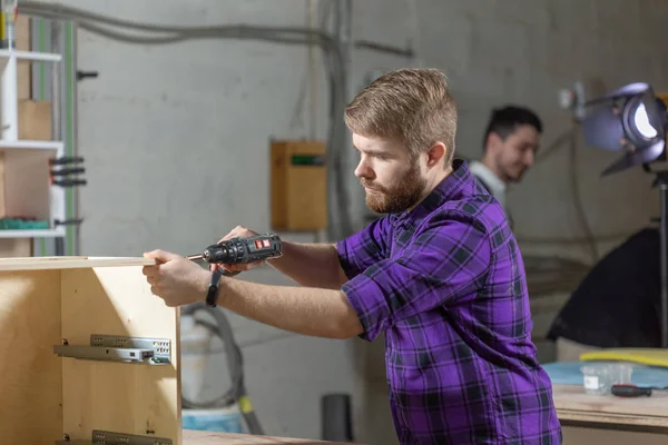 Fábrica de muebles, pequeñas empresas y concepto de personas - Trabajador joven trabaja en una fábrica para la producción de muebles —  Fotos de Stock