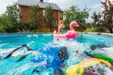 Çöp sorunu, plastik geri dönüşüm, kirlilik ve çevre kavramı - aptal kadın yüzer ve kirli bir havuzda eğlenin. Şişeler ve plastik torbalar onun yanında yüzer.