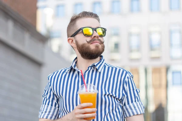 Bottom View portret van een stijlvolle jonge hipster man in spiegel glazen met SAP op de achtergrond van het Business Center. Urban Holiday in het weekend concept. — Stockfoto