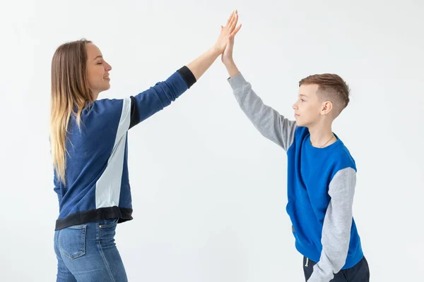 La encantadora madre y el hijo se aplauden mientras disfrutan de un traslado perfecto a un nuevo apartamento. El concepto de trasladar a una familia joven . —  Fotos de Stock