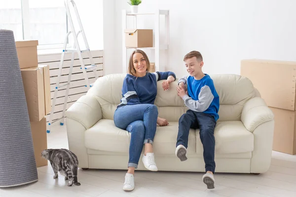 Satisfeito feliz caucasiano mãe e filho comunicam alegremente discutindo o deisgn do novo apartamento durante a festa de inauguração com seu gato escocês . — Fotografia de Stock