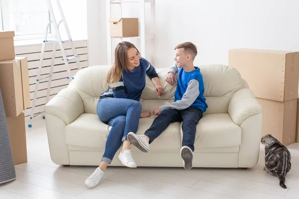 Nöjda lycklig kaukasiska mor och son glatt kommunicera diskutera deisgn av den nya lägenheten under inflyttnings fest med sin skotska Fold katt. — Stockfoto