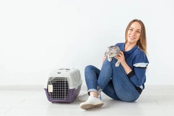 Okouzlující mladá žena má v rukou svou krásnou šedivou skotskou kočku, která sedí na podlaze v novém bytě. Koncepce PET. — Stock fotografie