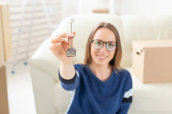 Переезд, недвижимость и покупка квартиры - Happy single woman apartment owner or renter showing keys and looking at you — стоковое фото