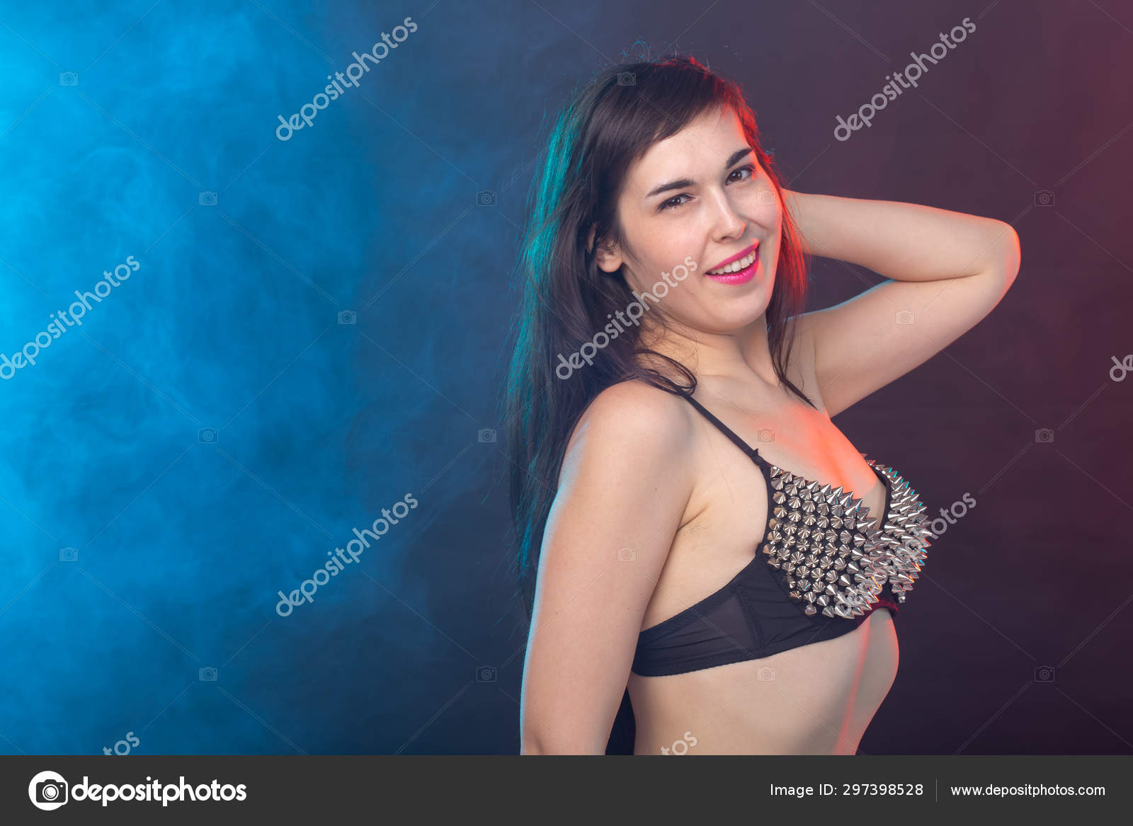 Beautiful young sexy brunette woman posing on a dark background in a  riveted top on a dark background. The concept of grooming and  attractiveness. Stock Photo by ©Satura_ 297398528