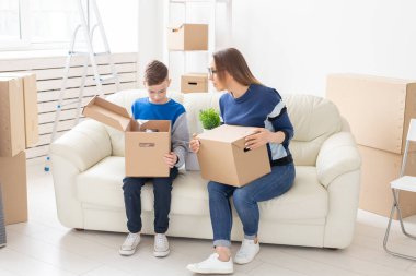 Sevimli tek anne ve küçük çocuk oğlu hareketten sonra şeyler ile kutuları sıralamak. Ev ısıtma ipotek kavramı ve yeni konut sevinç.