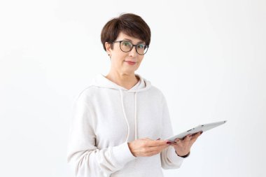 Teknolojiler ve modern insanlar kavramı-güzel kadın 50 kısa saçlı ışık odasında tablet tutarak eski yıl