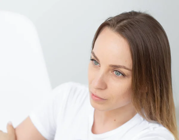 Pretty good looking stylish woman posing on white wall background, close-up. The concept of a strong independent purposeful young woman.