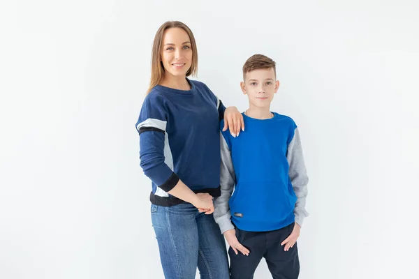 La crianza de los hijos, la familia y el concepto de padre soltero - Una madre feliz y un hijo adolescente riendo y abrazando en el fondo blanco —  Fotos de Stock