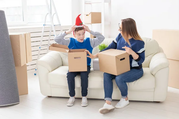 Милая мать-одиночка и маленький мальчик-сын сортируют коробки с вещами после переезда. Концепция ипотеки на новоселье и радость от нового жилья . — стоковое фото