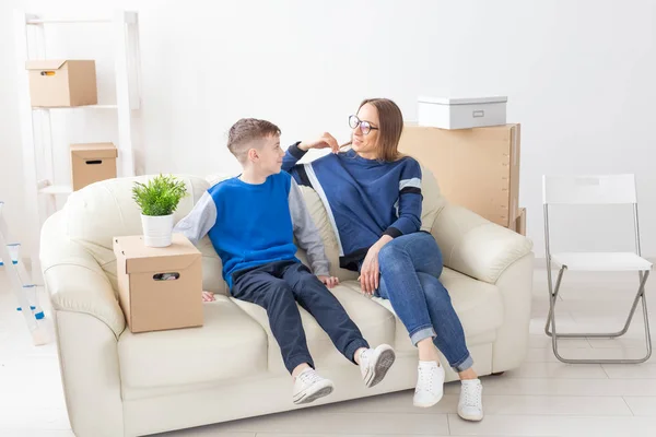 Charming pretty woman young single mother warmly communicates with her son discussing the new plan while moving to a new house — Stock Photo, Image