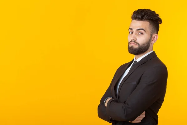 Encantador jovem empresário auto-confiante vestindo roupas formais posando em um fundo amarelo com espaço de cópia. Conceito de negócio e sucesso . — Fotografia de Stock