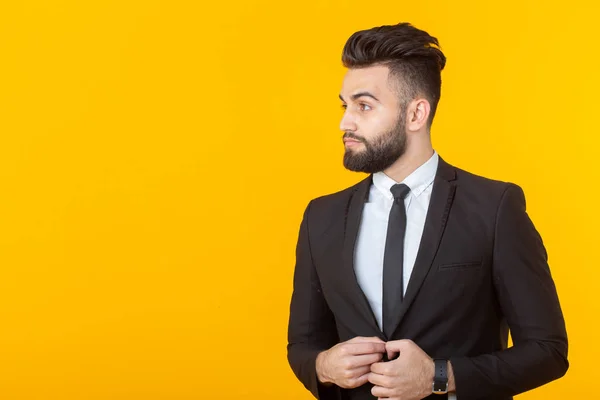 Encantador joven empresario seguro de sí mismo con ropa formal posando sobre un fondo amarillo con espacio para copiar. Concepto de negocio y éxito . — Foto de Stock