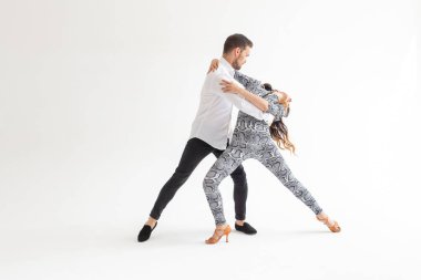 Genç çift dans latin dans bachata, merengue, salsa, kizomba. Kopyalama alanı ile beyaz arka plan üzerinde iki zerafet poz