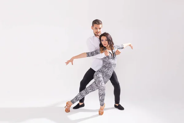 Молода пара танцює соціальну латинську танцювальну бачату, меренг, сальсу. Дві елегантні пози на білому тлі з простором для копіювання — стокове фото