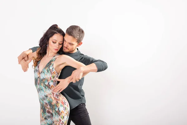 Junges Liebespaar tanzt sozialen Tanz kizomba oder bachata über weißem Hintergrund mit Kopierraum — Stockfoto