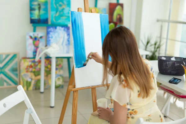 Clase de arte y concepto de dibujo - Mujer artista trabajando en la pintura en el estudio . —  Fotos de Stock