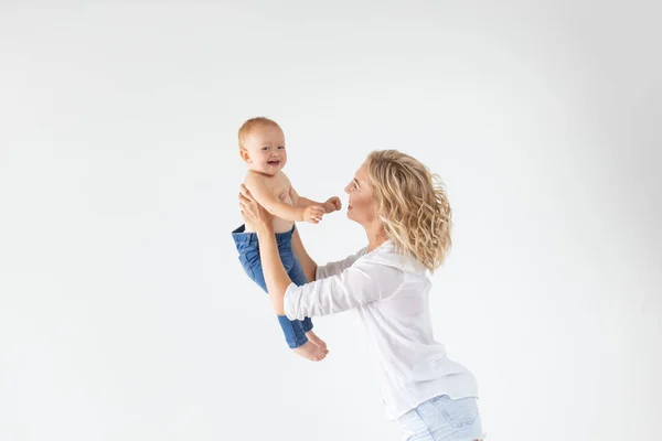 Concepto de familia, maternidad y familia - Madre joven sosteniendo a su bebé sobre un fondo blanco — Foto de Stock