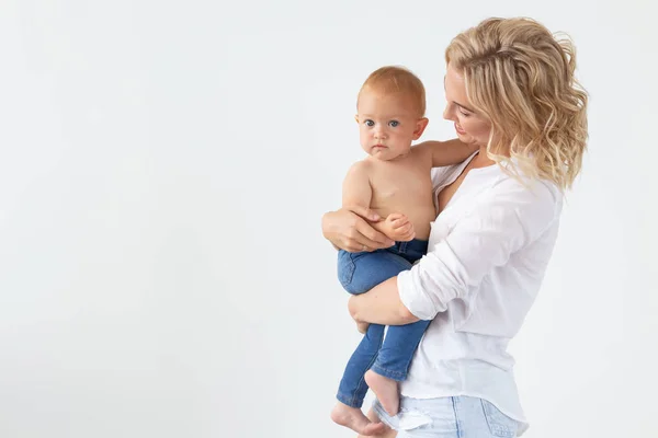 Aile, annelik ve aile kavramı - Genç anne copyspace ile beyaz arka plan üzerinde bebeğini tutan — Stok fotoğraf