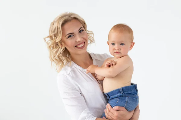 Concepto de madre soltera, maternidad y niñez: madre que sostiene a la dulce niña sobre un fondo blanco — Foto de Stock