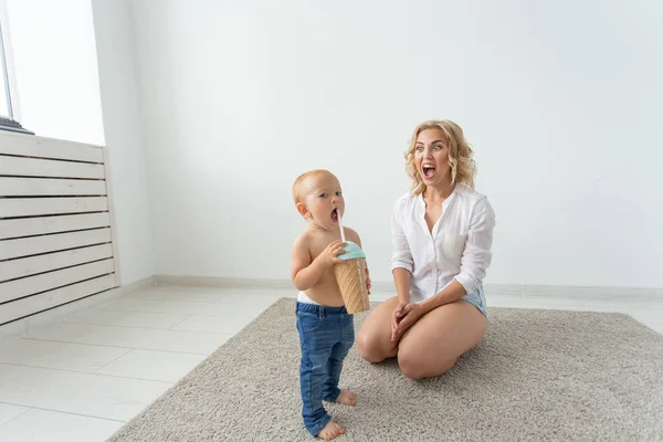Familien-, Kinder- und Elternschaftskonzept - glücklich lächelnde junge Mutter spielt zu Hause mit kleinem Baby — Stockfoto