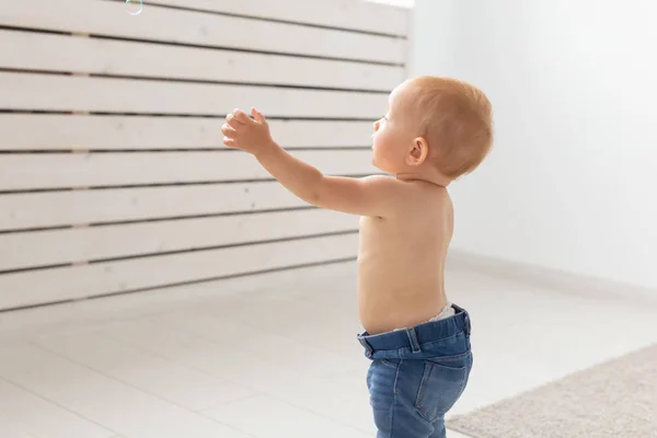 Kindheit, Kindheit, Emotionen und Menschenkonzept - Nahaufnahme eines glücklichen kleinen Jungen oder Mädchens zu Hause — Stockfoto