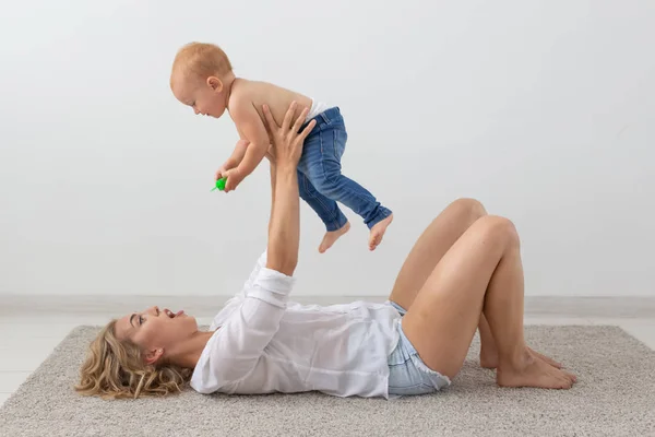 Conceito de família, criança e paternidade - feliz sorridente jovem mãe brincando com o bebê em casa — Fotografia de Stock