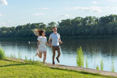 Yaz doğa, ilişki ve aşk kavramı insanlar - mutlu çift göl yakınında çalışan