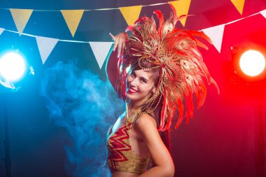Karnaval, oryantal dans ve tatil konsepti - Altın kostüm giyen ve gülümseyen güzel kadın samba dansçısı