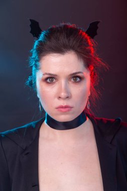 Cadılar Bayramı, tatil ve karnaval konsepti - ceket kadın ve gotik tarzı yarasa kulakları ile.