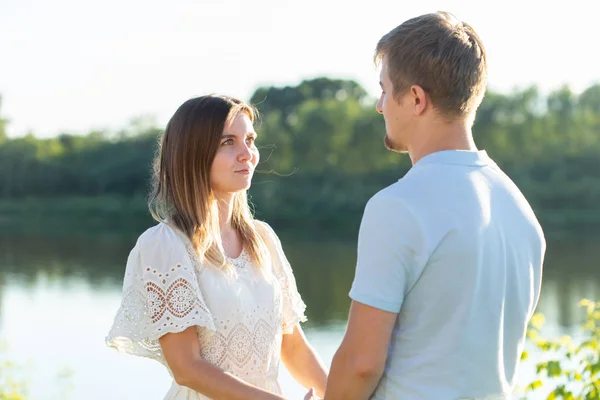 Maravilhoso jovem casal de mãos dadas e desfrutar da vida em conjunto com a atividade natural de lazer ao ar livre estilo de vida na natureza eo pôr do sol na luz de fundo . — Fotografia de Stock