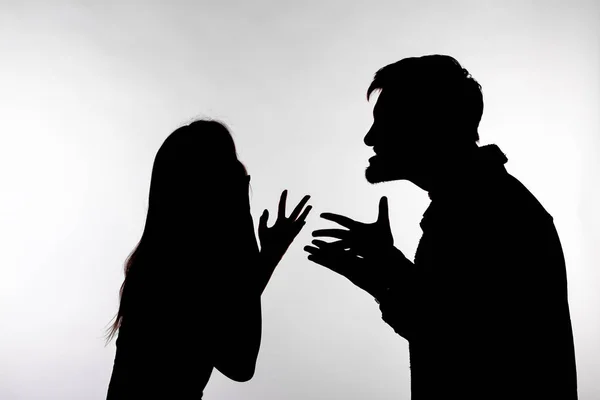 Difficultés relationnelles, conflit et concept de maltraitance - homme et femme face à face hurlant en criant l'un à l'autre silhouette querelle isolée sur fond blanc — Photo