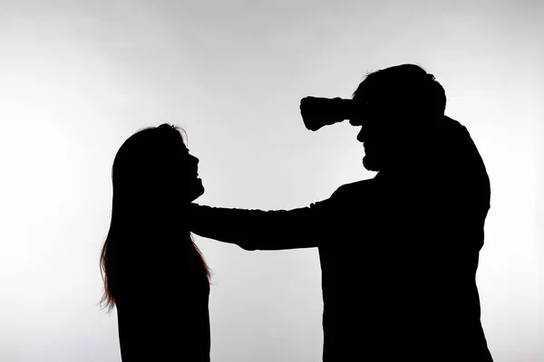 Domestic violence and abuse concept - Silhouette of man beating defenseless woman — Stock Photo, Image