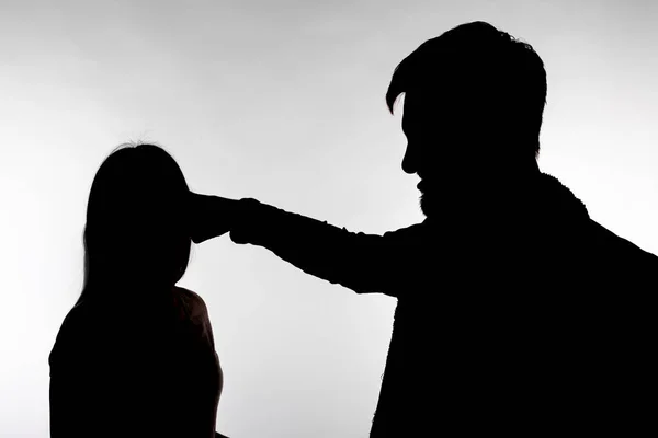 Violência doméstica e conceito de abuso - Silhueta de homem espancando mulher indefesa — Fotografia de Stock