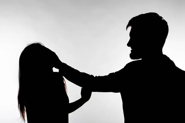 Domestic violence and abuse concept - Silhouette of man beating defenseless woman — Stock Photo, Image