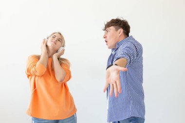 Genç üzgün adam onu dinlemek için onun kadın yalvarıyor ama o beyaz bir arka plan üzerinde poz kulaklık ile müzik dinler. Yanlış anlama ve diyaloğa girme konusundaki isteksizlik.