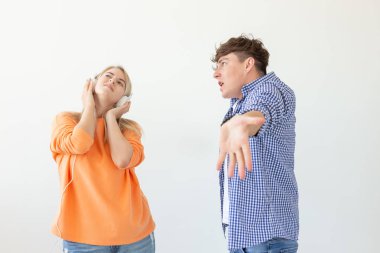 Genç üzgün adam onu dinlemek için onun kadın yalvarıyor ama o beyaz bir arka plan üzerinde poz kulaklık ile müzik dinler. Yanlış anlama ve diyaloğa girme konusundaki isteksizlik.