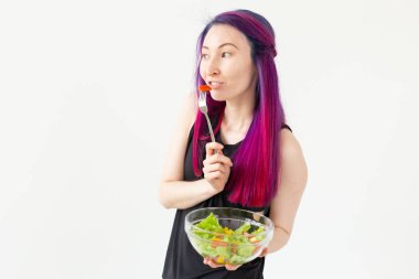 Fiziksel eğitim den sonra hafif bir yunan salatası yeme renkli saçlı Pozitif karışık ırk hipster kız. Doğru beslenme ve kilo kaybı kavramı.