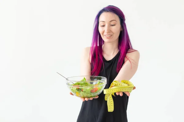 야채 샐러드와 측정 테이프를 들고 젊은 피트니스 블로거 소녀. 스포츠 라이프 스타일과 적절한 영양의 개념. 복사 공간이 있는 흰색 배경 — 스톡 사진